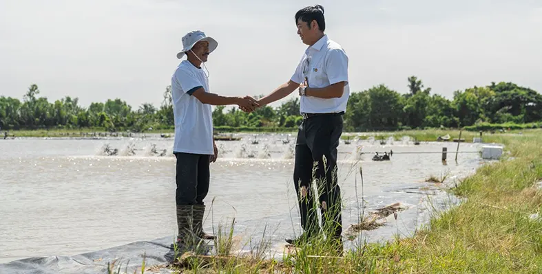 Image_shows_two_men_shaking_hands_in_a_field_signifying_Aboitiz_Foods_preparing_to_debut_at_VIV_Asia_2025