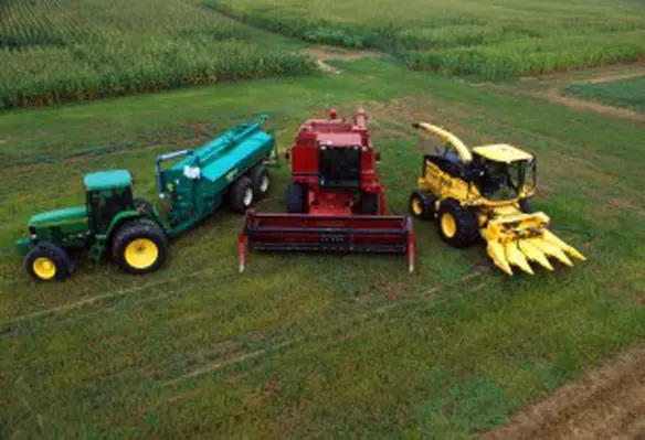 Many farm machines at ARS Beltsville Agricultural Research Center are running on a mixture of diesel fuel and biodiesel, which is made from soybean oil. – from left to right: John Deere 7800 tractor with Houle slurry trailer, Case IH combine harvester, New Holland FX 25 forage harvester with corn head. (Image source: Bob Nichols/Commons)